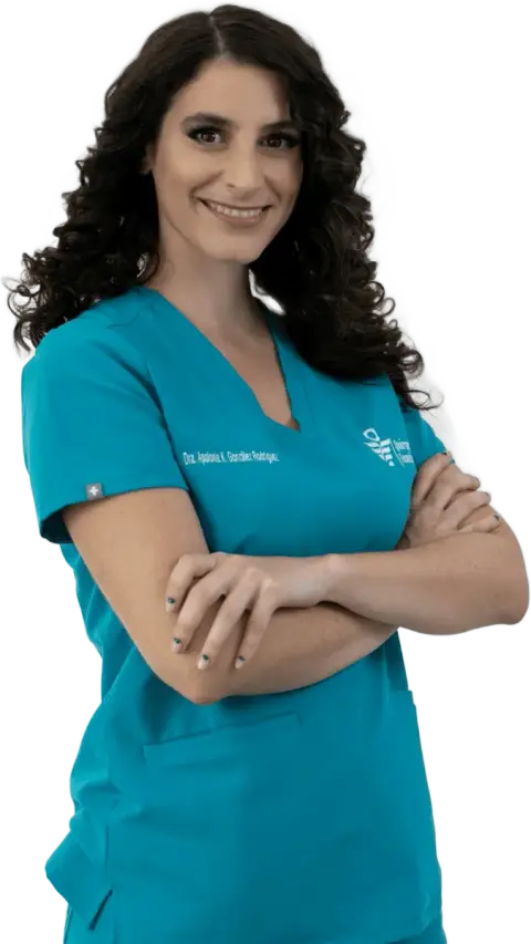 Smiling doctor in teal scrubs with arms crossed