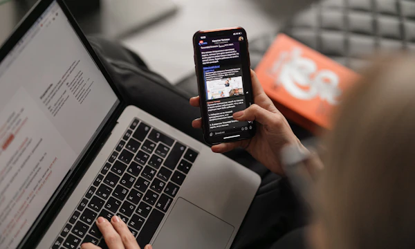 Scrolling competitor results on a phone over a laptop